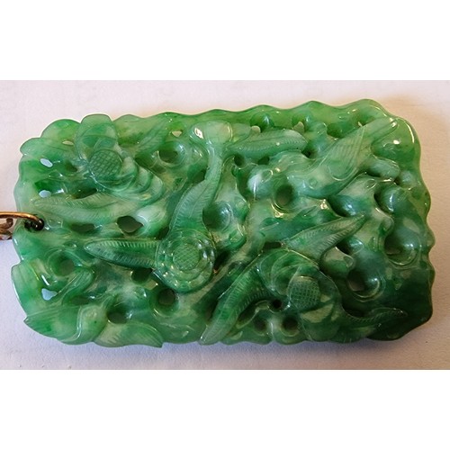 127 - A Chinese green jade pendant, late Qing/Republic period, carved and pierced with birds amongst folia... 