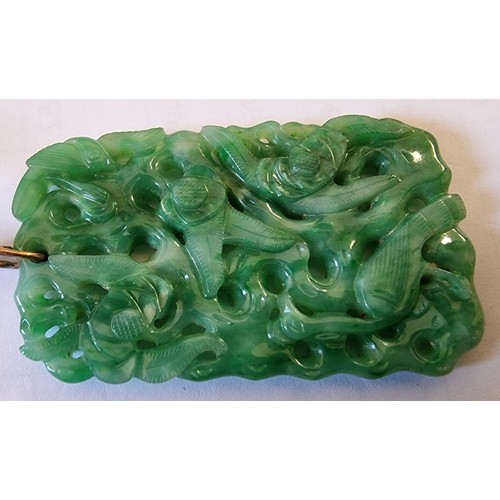 127 - A Chinese green jade pendant, late Qing/Republic period, carved and pierced with birds amongst folia... 