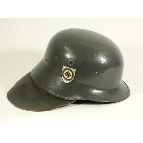 245 - A replica German ''stahlhelm', decorated with painted swastika, with leather neck protector