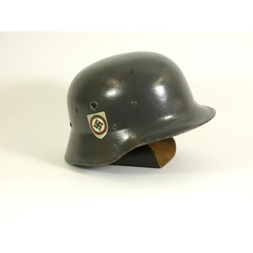 245 - A replica German ''stahlhelm', decorated with painted swastika, with leather neck protector