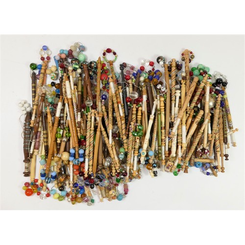 147 - A collection of 139 mainly fruit and hardwood turned bobbins, with spangles, some bone and glass, ma... 