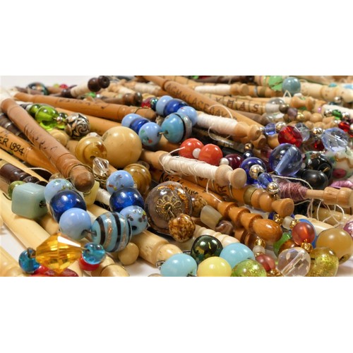 147 - A collection of 139 mainly fruit and hardwood turned bobbins, with spangles, some bone and glass, ma... 