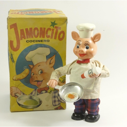 183 - A Jamoncito cocinero cooking chef automaton, in the form of pig, plastic with fabric clothing, wind ... 