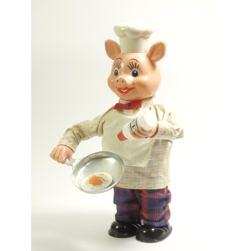 183 - A Jamoncito cocinero cooking chef automaton, in the form of pig, plastic with fabric clothing, wind ... 