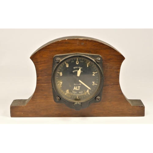 253 - A 35,000 feet altimeter mounted in an oak frame, broad arrow mark to reverse and a Military marching... 