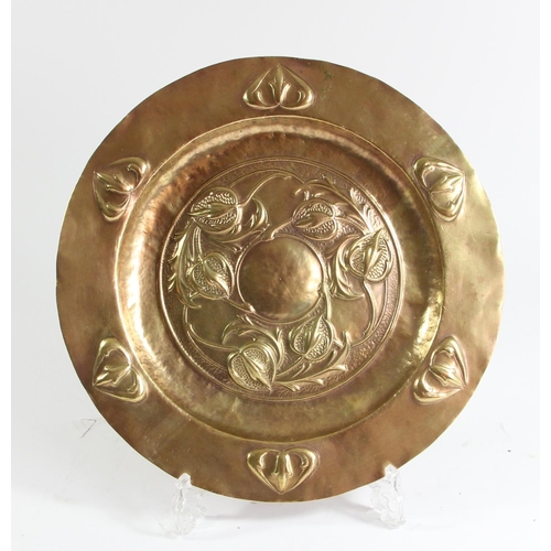 77 - An Arts and Crafts brass platter, probably Scottish school, embossed with thistles, 28.5cm