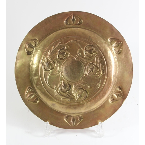 77 - An Arts and Crafts brass platter, probably Scottish school, embossed with thistles, 28.5cm