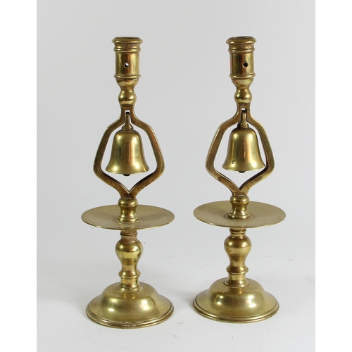 78 - A pair of 19th century brass tavern type socket candlesticks with central column bell and circular d... 