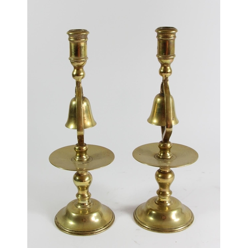 78 - A pair of 19th century brass tavern type socket candlesticks with central column bell and circular d... 