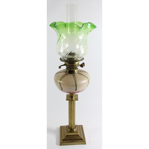 79 - An Art Nouveau glass and brass oil lamp, the iridescent bowl in the manner of Loetz, reeded column t... 