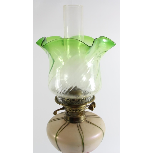 79 - An Art Nouveau glass and brass oil lamp, the iridescent bowl in the manner of Loetz, reeded column t... 