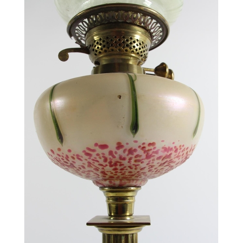 79 - An Art Nouveau glass and brass oil lamp, the iridescent bowl in the manner of Loetz, reeded column t... 