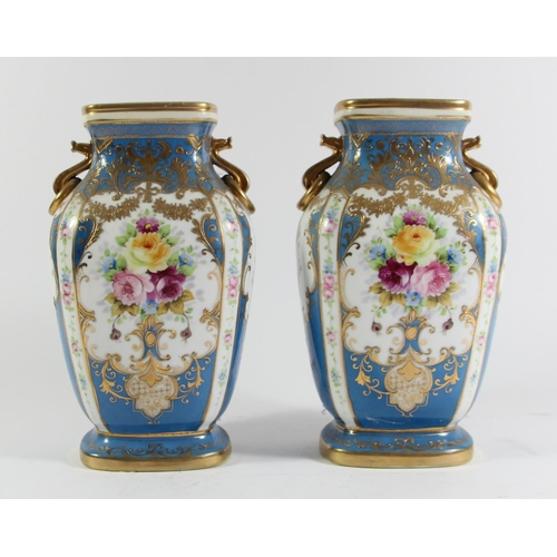 146 - A Japanese pair of Noritake vases, decorated with panels of flowers and gilt on a blue ground, 23cm.