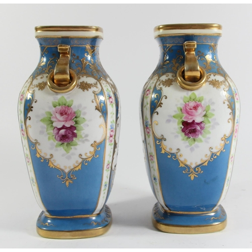 146 - A Japanese pair of Noritake vases, decorated with panels of flowers and gilt on a blue ground, 23cm.