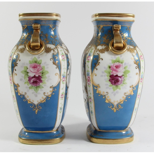 146 - A Japanese pair of Noritake vases, decorated with panels of flowers and gilt on a blue ground, 23cm.