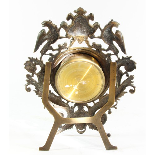 221 - A Victorian cast brass easel mantle clock, the frame with Griffins either side of a shield, floral s... 