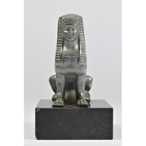 52 - A base metal car mascot in the form of a seated Sphynx mounted on a black onyx base, 11cm.