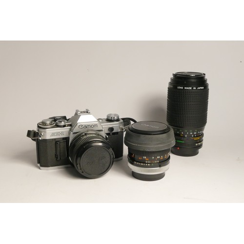 90 - A Canon AE-1 35mm film camera, with three lens, including a Canon FD 28mm f2.8, Canon FD 50mm f1.8, ... 