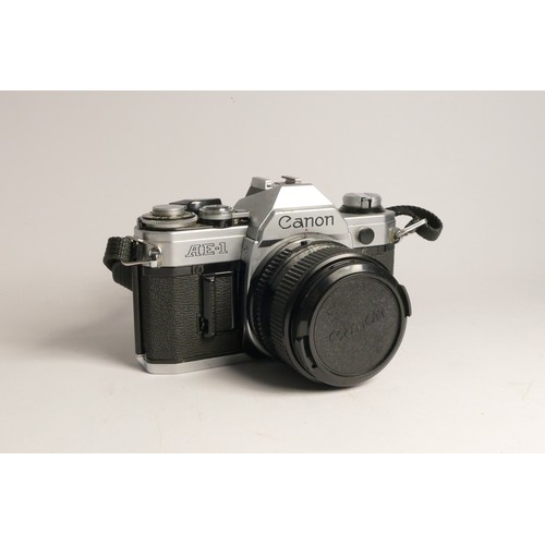 90 - A Canon AE-1 35mm film camera, with three lens, including a Canon FD 28mm f2.8, Canon FD 50mm f1.8, ... 