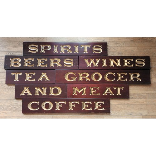 159 - Eight Edwardian mahogany grocer's shop signs, hand carved, gilt decoration, to include 

Wines, 92cm... 