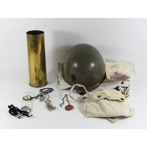 329 - A WWII brass 25lb shell case, dated 1944, a metal helmet, two white canvas kit bags, two compasses, ... 