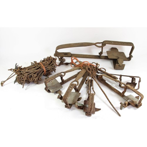 334 - A vintage wrought iron animal trap, 55cm, five smaller examples and a measuring chain