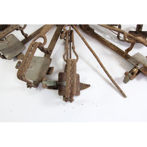 334 - A vintage wrought iron animal trap, 55cm, five smaller examples and a measuring chain