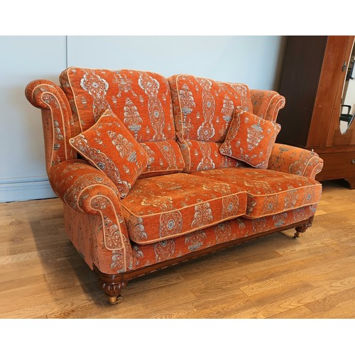 408 - A Parker Knoll two seater sofa, upholstered in a baslow terracotta medallion gold fabric, raised on ... 