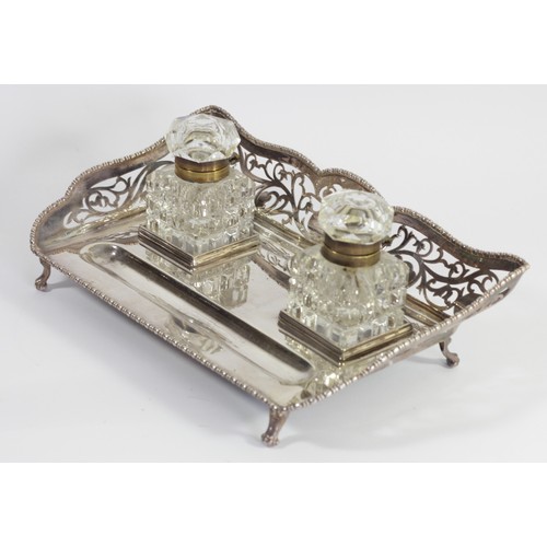 61 - An electroplated two bottle desk stand, 3/4 pierced gallery with gadrooned border, cut glass brass m... 