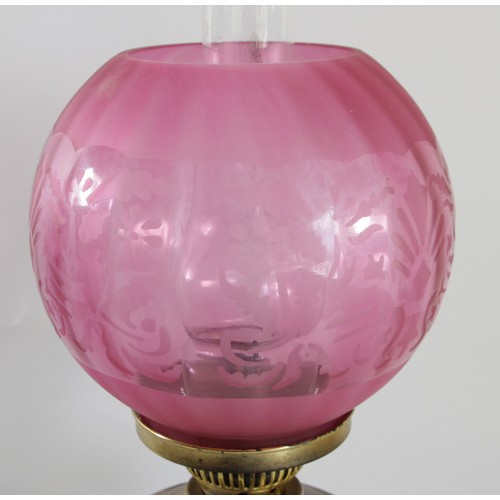 191 - A brass oil lamp, with etched ruby glass shade, Sun clear glass funnel, 62cm