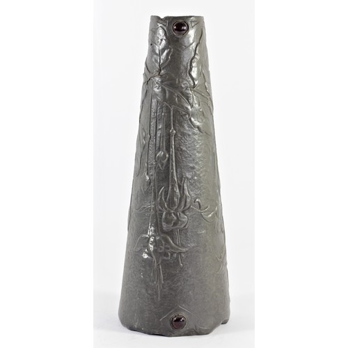 194 - An Art Nouveau continental pewter vase, of tapering form, with embossed floral decoration and red gl... 