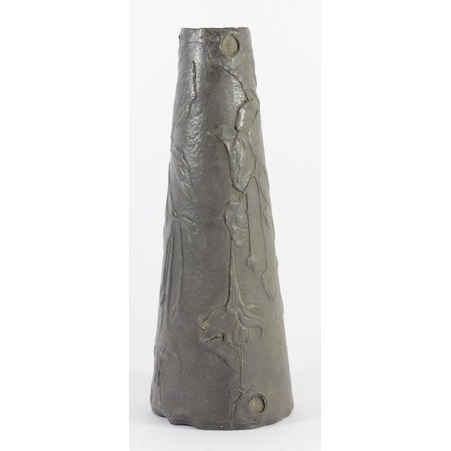 194 - An Art Nouveau continental pewter vase, of tapering form, with embossed floral decoration and red gl... 