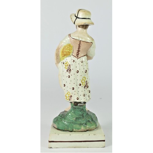 251 - A pearlware figurine of Summer, c.1800-1820, modelled as a girl with sickle and sheath of corn, in e... 