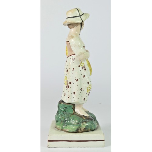 251 - A pearlware figurine of Summer, c.1800-1820, modelled as a girl with sickle and sheath of corn, in e... 