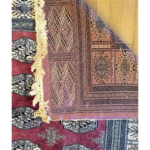 215 - A Pakistani Peshawar Bokhara carpet, with red field and multiple guls, 360 x 290cm, A/F, 1989 receip... 