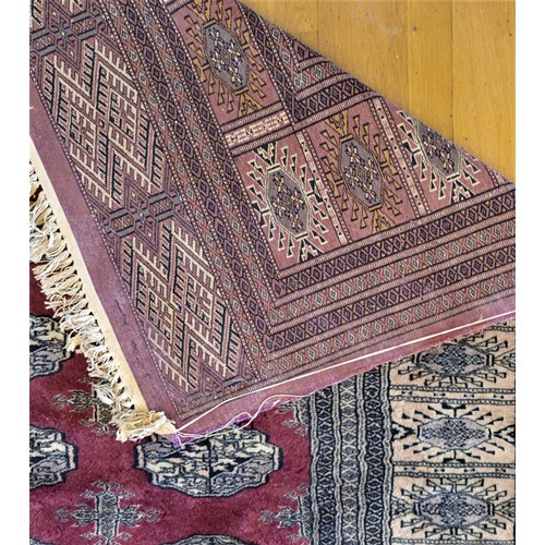 215 - A Pakistani Peshawar Bokhara carpet, with red field and multiple guls, 360 x 290cm, A/F, 1989 receip... 