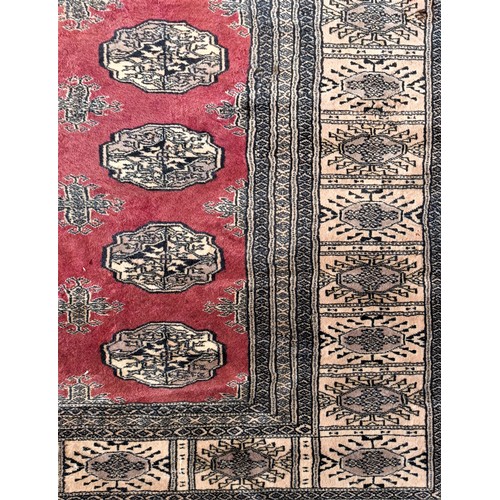 215 - A Pakistani Peshawar Bokhara carpet, with red field and multiple guls, 360 x 290cm, A/F, 1989 receip... 