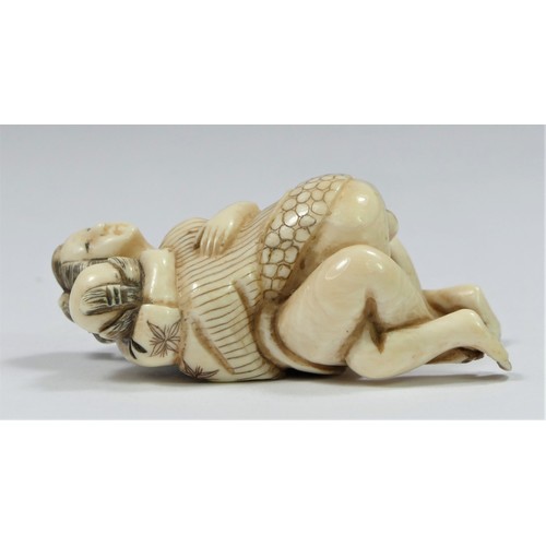 281 - A Taishō period carved ivory netsuke of a copulating couple, signed, 5cm.