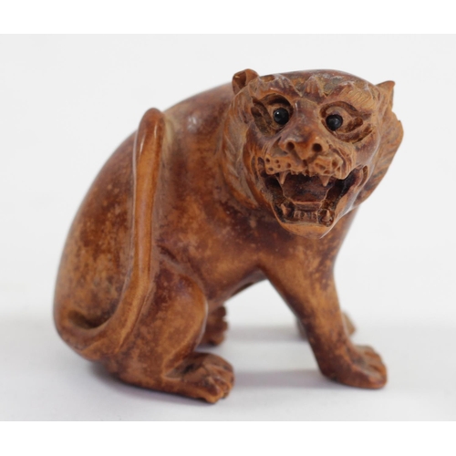 287 - A Japanese wood netsuke of a seated dog, mother of pearl disc signed, 5cm and three other wooden net... 