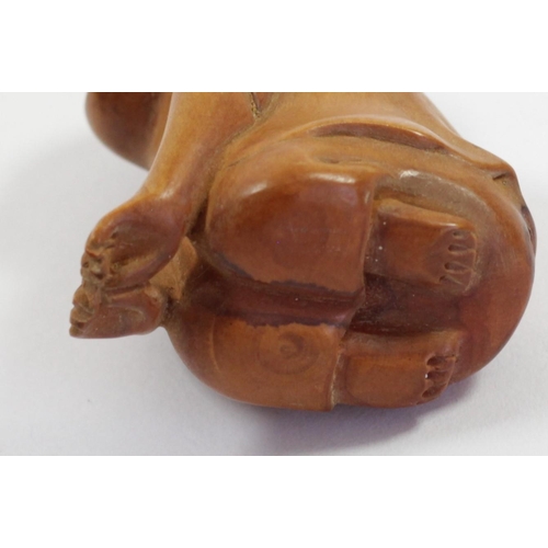 289 - A Japanese wood netsuke of a phallus with face, signed, 4.5cm, a wooden netsuke of the four faced Bu... 