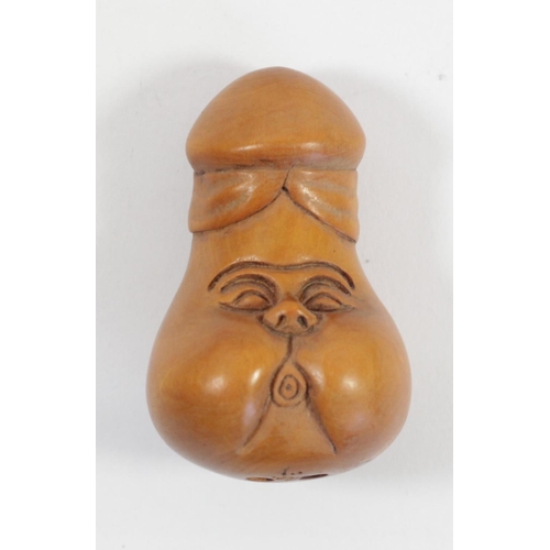 289 - A Japanese wood netsuke of a phallus with face, signed, 4.5cm, a wooden netsuke of the four faced Bu... 