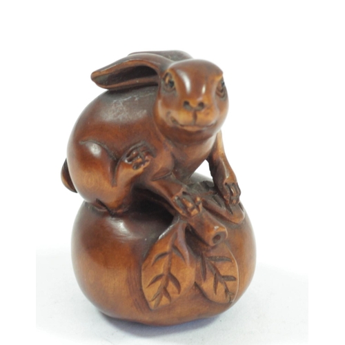 291 - A Japanese wood netsuke of a rabbit on an apple, signed, 4.5cm, two rabbits with babies on their bac... 