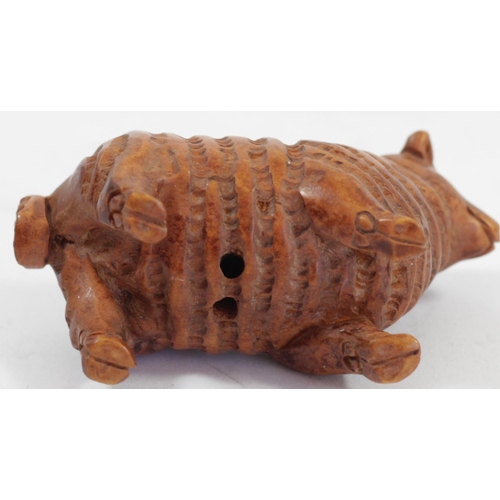 292 - A Japanese wood netsuke of a ram in a hand, signed, 5cm, together with a pig holding a basket, signe... 