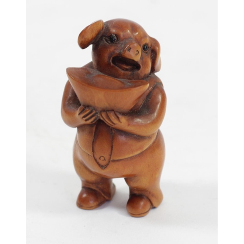 292 - A Japanese wood netsuke of a ram in a hand, signed, 5cm, together with a pig holding a basket, signe... 