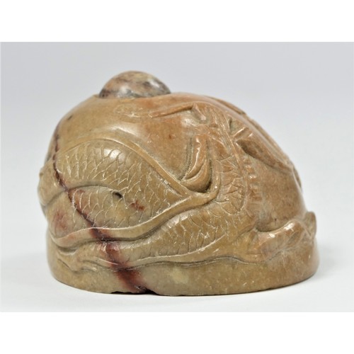 297 - A Chinese carved soapstone depicting two dragons chasing a spinning sacred pearl, 5cm