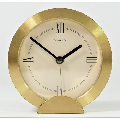 304 - Tiffany & Co. a gilt brass circular quartz alarm clock, number 205738, diameter 88mm, pouch and box.