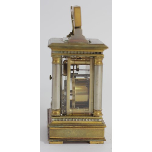 309 - A miniature brass carriage time piece, the gilt brass case with silvered columns, main spring broken... 