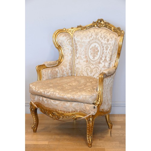 353 - A Louis XV style mahogany framed wing back armchair, with carved giltwood frame, sprung upholstered,... 