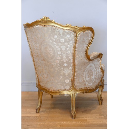 353 - A Louis XV style mahogany framed wing back armchair, with carved giltwood frame, sprung upholstered,... 