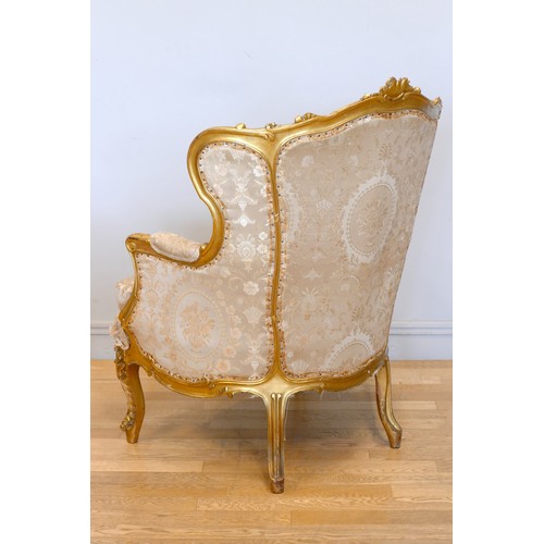 353 - A Louis XV style mahogany framed wing back armchair, with carved giltwood frame, sprung upholstered,... 